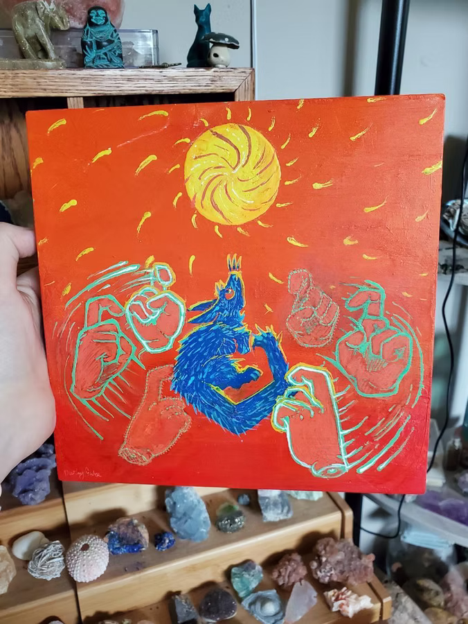 An acrylic painting on canvas in a expressionist style depicting a stylized rat with a sharp angular body as seen from the side looking up at a yellow circle representing the sun. The rat is a deep ultramarine blue with cyan accents and red eyes. Around it there are "ghostly" depictions of 6 hands with their pointer finger half opened with different opacity levels with a cyan border around them, cyan lines representing circular motion are present around the hands. The background is a gradient going from red to orange, little curved yellow lines flow outward from the "Sun" representing rays.
The painting is in front of a rock and shell collection